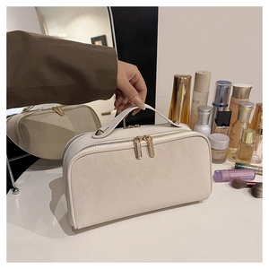Gros plan sur la grande trousse de toilette crème avec double zip et poignée
