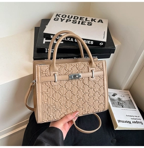 Close-up of beige woven texture handbag with silver twist-lock and structured handles