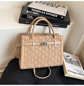Detail shot of khaki crossbody bag featuring quilted texture and metallic buckle closure