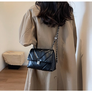 Detailansicht der gesteppten schwarzen Ledertasche mit Silberkette und Drehverschluss