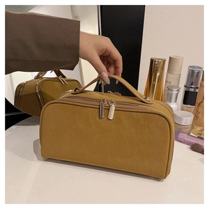 Vue détaillée d'une trousse de maquillage jaune moutarde en cuir PU et zips dorés