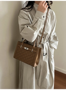 Brown Kelly bag with geometric texture worn by a model in a minimalist indoor setting