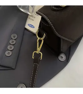 Close-up of deep brown leather bag featuring vintage gold hardware and contrast stitching