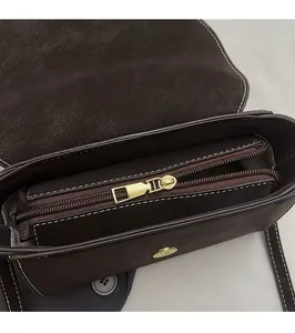 Detailed interior of dark brown crossbody bag with high-quality golden metal zipper