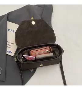 Interior view showing the large capacity of a retro brown crossbody bag with items