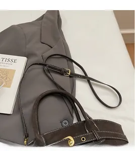 Detail of dark coffee dumpling bag featuring white contrast stitching and gold metal hardware