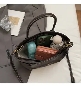 Internal view of dark brown dumpling bag showing space for phone, wallet and umbrella