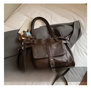 Close-up of vintage brown tote bag with buckle pocket and cute bear doll charm
