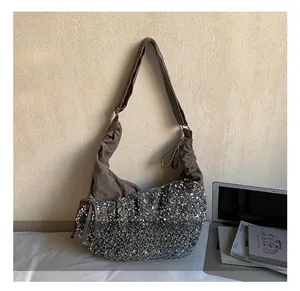 Detail of sequin patchwork crossbody bag with brown linen trim and side knot accents