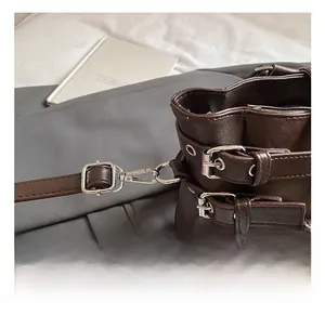 Close-up of premium silver metal spring hook and buckle on brown leather tote bag