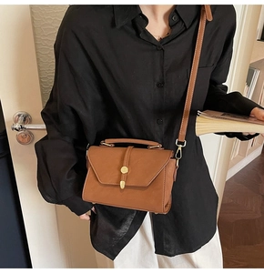 Retro brown leather crossbody square bag with gold buckle worn by model in casual setting