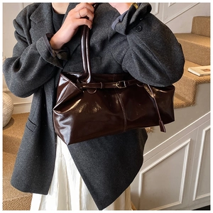 Detailed shot of vintage chocolate oil-wax leather tote bag with glossy finish and metal buckle