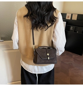 Model view showing the back profile of a retro dark brown crossbody bag in home interior