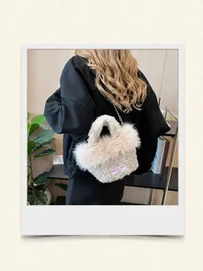 Détail du sac seau en peluche blanche avec bandoulière chaîne et étiquette brodée