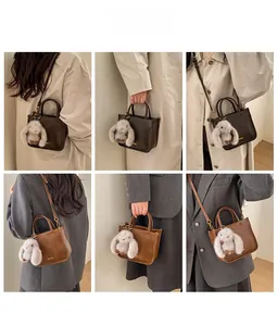 Retro shoulder bag with plush rabbit charm shown with trench coat and blazer
