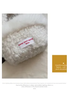 Détail du sac en laine d'agneau blanche avec étiquette tissée et texte rouge brodé