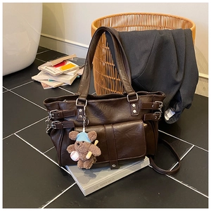 Detailed view of dark brown PU leather tote with silver hardware and a cute bear pendant