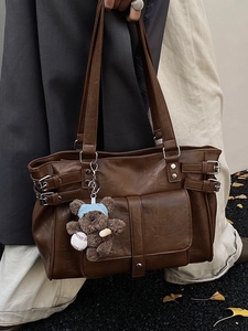 Brown vintage faux leather tote bag with decorative buckles and a cute teddy bear charm