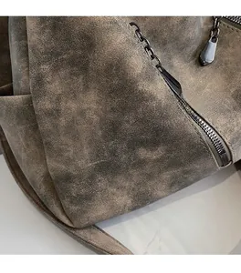 Détail du tissu givré marron vintage avec fermeture éclair en métal foncé sur le sac