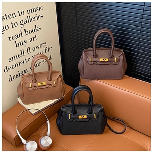 Detailed view of leather handbags in black, brown, and coffee with gold hardware accents