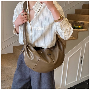 Modern olive green crescent hobo bag with wide shoulder strap shown on a model