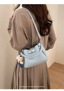 Détail de vue arrière du sac seau en cuir bleu clair texturé avec charm ours mignon