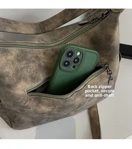 Vue détaillée de la poche arrière zippée antivol sur un sac cabas vintage marron