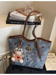 Blue-grey canvas tote bag with embroidery details and a cute teddy bear pendant charm
