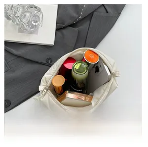 Detailed top view of a cream quilted pouch showing large capacity for phone and cosmetics