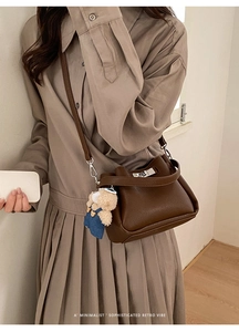 Détail du sac seau marron café avec texture grainée et un pendentif ours en peluche mignon