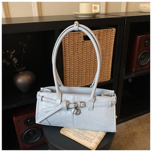 Close-up of light blue rectangle handbag with long handles and metal buckle accents