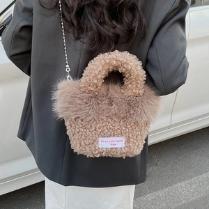 Detail of faux fur crossbody bag featuring curly lamb wool texture and metal chain