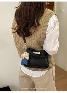 Vue détaillée du sac seau en cuir noir grainé avec fermoir argenté et pendentif ours
