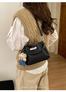 Vue arrière du sac seau noir en cuir grainé avec fermoir argenté et charm ours peluche