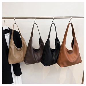 Minimalist tote bags in khaki, brown, black and tan colors hanging on a rack