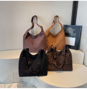 Showcasing four colors of large vintage matte suede hobo bags on geometric display stands