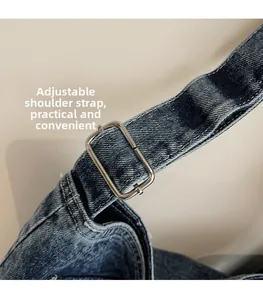 Detail of adjustable denim shoulder strap with silver buckle on a stylish tote bag
