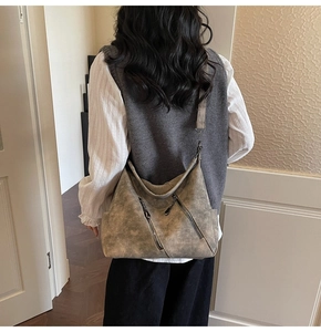 Gros plan d'un grand sac cabas rétro gris foncé à texture mate sur un modèle femme