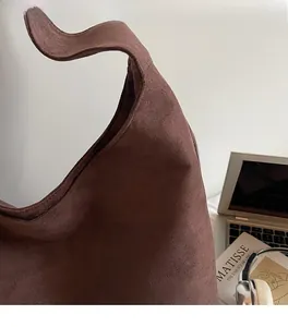 Close-up of retro dark brown matte suede texture on a large capacity shoulder bag