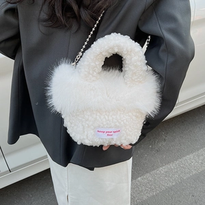 Detail of white faux fur handbag with pink text label and silver bead metal chain