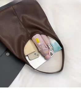 Spacious interior of brown lychee grain leather tote bag with various daily essentials