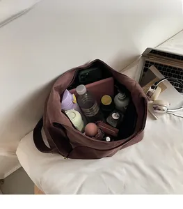 Spacious interior of a large faux suede tote bag showing storage for laptop and umbrella