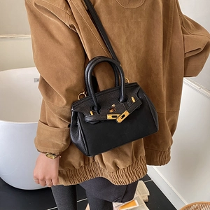 Classic black lychee pattern handbag with gold metal lock and leather texture detail