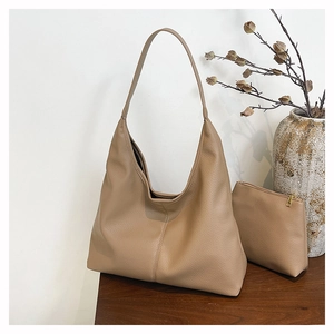 Detail of beige hobo shoulder bag with pebble grain leather texture and small pouch