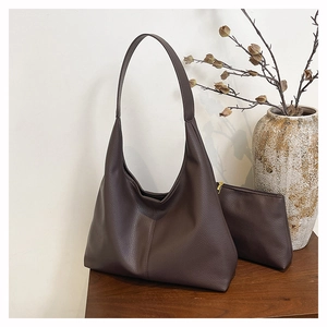 Macro detail of dark brown litchi grain leather tote bag with matching pouch
