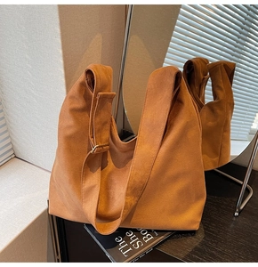 Detailed texture of caramel suede tote bag with adjustable wide shoulder strap