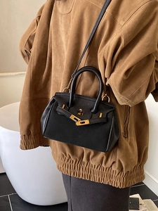 Vintage black lychee pattern Kelly bag with gold hardware shown on a model's shoulder