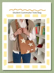 Detail of a brown suede tote bag featuring white star patches and a ruched shoulder strap