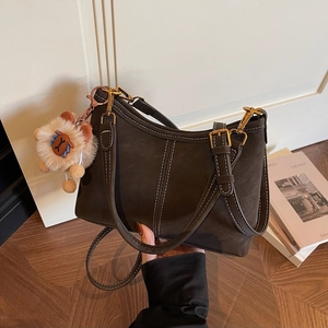 Vintage dark brown bucket bag with contrast stitching and lion plush charm accessory