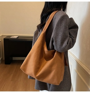 Detailed view of the soft brown suede texture on a large capacity shoulder tote bag